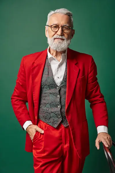 Schöner Mann als Weihnachtsmann mit Brille und Hand auf der Rückenlehne, Blick in die Kamera, winterliches Konzept — Stockfoto