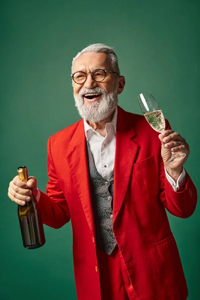 Веселый человек, одетый как Санта с бородой наслаждаясь шампанским и улыбаясь искренне, зимняя концепция — стоковое фото