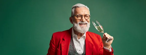 Jolly Santa in red elegant suit testing champagne and smiling at camera, winter concept, banner — Stock Photo