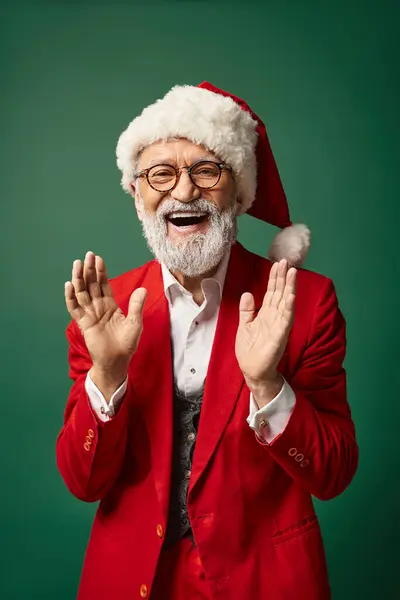 Feliz Papá Noel con estilo en el sombrero de Navidad gesticulando activamente y sonriendo a la cámara, concepto de invierno - foto de stock