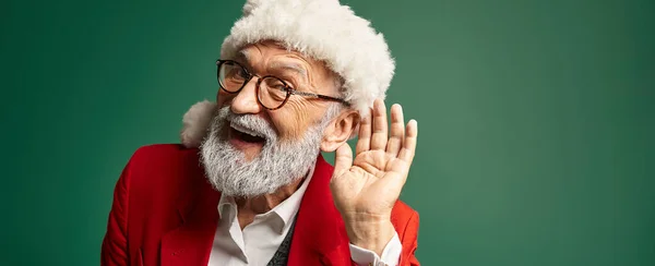 Homme joyeux habillé en Père Noël avec chapeau rouge avec la main près de l'oreille regardant la caméra, concept d'hiver, bannière — Photo de stock
