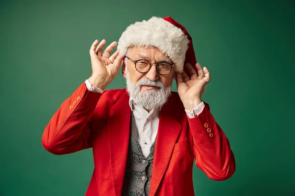 Handsome elegant Santa with white beard looking at camera touching hat with hands, winter concept — Stock Photo