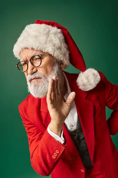 Serious white bearded Santa gesturing on dark green backdrop looking at camera, winter concept — Stock Photo