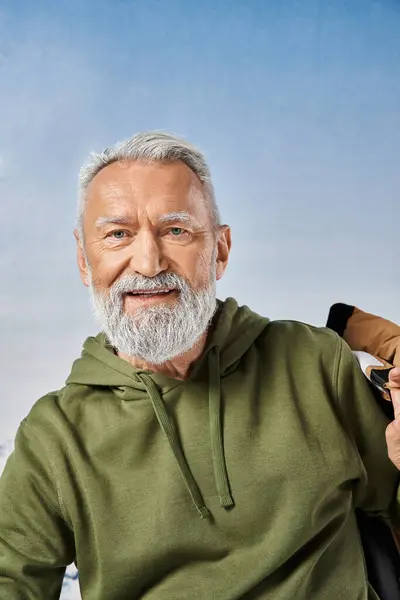 Joyous Santa with white beard looking at camera with snowy mountain on backdrop, winter concept — Stock Photo