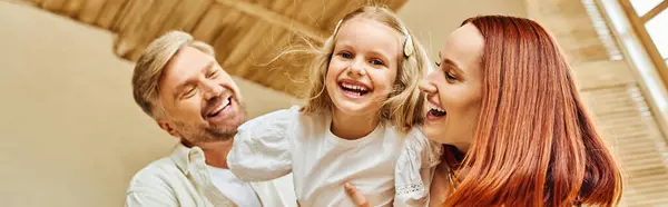 Happy parents embracing adorable daughter and having fun in kitchen at home, horizontal banner — Stock Photo