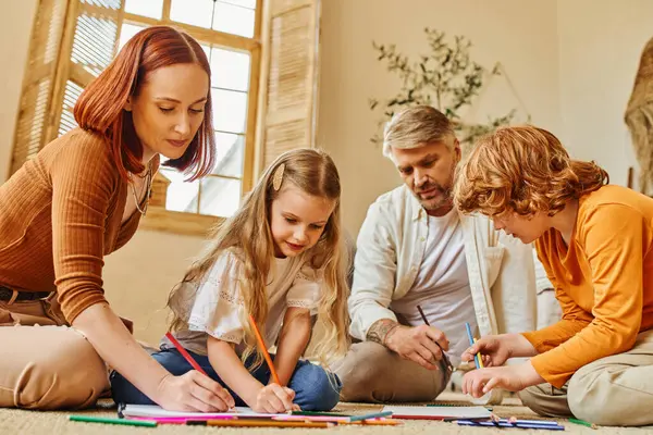 Niños felices dibujando junto con los padres en el suelo en acogedora sala de estar, actividades creativas - foto de stock