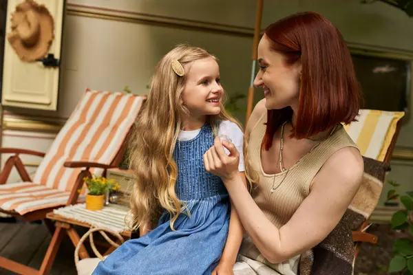 Joyful mother and daughter looking at each other near modern trailer home, leisure and bonding — Stock Photo