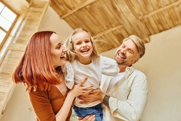 Glückliche Eltern spielen mit überglücklicher Tochter im Wohnzimmer zu Hause, verbindende Momente — Stockfoto