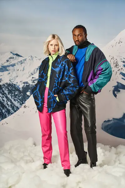 Стильна молода пара в теплому вбранні позує рукою на плечі зі сніжним тлом, зимова концепція — стокове фото