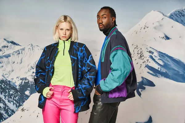 Stylish diverse couple in bright warm attire posing together and looking at camera, winter concept — Stock Photo