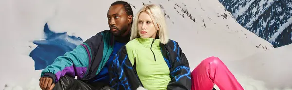 Beau couple multiculturel dans des tenues chaudes et lumineuses avec toile de fond de montagne, concept d'hiver, bannière — Photo de stock