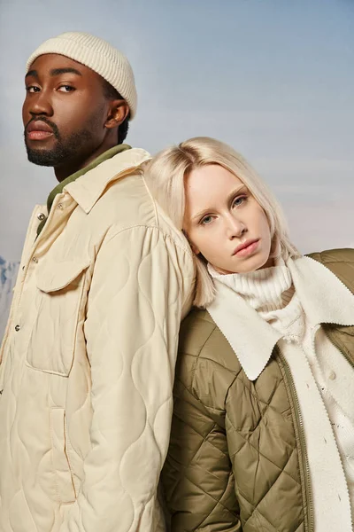 Портрет красивой многонациональной пары в теплых стильных нарядах, смотрящей в камеру, зимняя концепция — стоковое фото