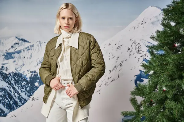 Attraktive Frau in stylischer Winterjacke posiert vor verschneiter Kulisse und blickt in die Kamera, Mode — Stockfoto
