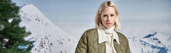 Hermosa mujer con estilo en chaqueta cálida modish con telón de fondo de montaña, moda de invierno, bandera - foto de stock