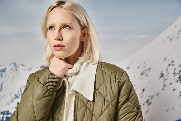 Bella donna bionda in giacca kaki posa con la mano sul mento e distogliendo lo sguardo, moda invernale — Foto stock