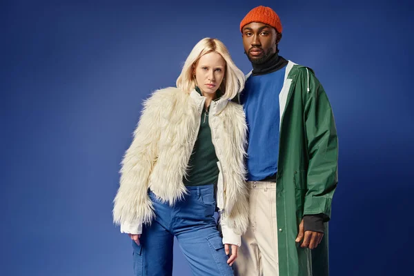 Pareja multiétnica posando en traje de invierno con la montaña en el telón de fondo, hombre y mujer afroamericanos - foto de stock