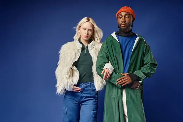 Pareja multiétnica posando en traje de invierno con la montaña en el telón de fondo, hombre y mujer afroamericanos - foto de stock