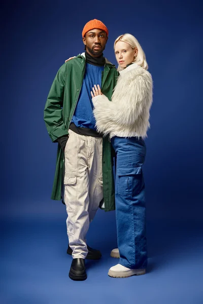 Мультиетнічна пара позує в зимовому вбранні з горою на фоні афроамериканця і жінки — стокове фото