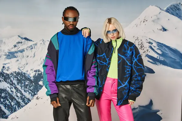 Multiethnic couple posing in winter attire with mountain on backdrop, african american man and woman — Stock Photo