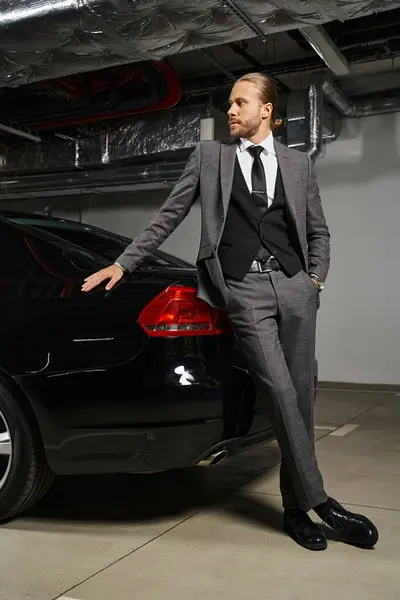 Atraente homem de negócios elegante em terno chique com gravata posando com a mão no bolso e olhando para longe — Stock Photo