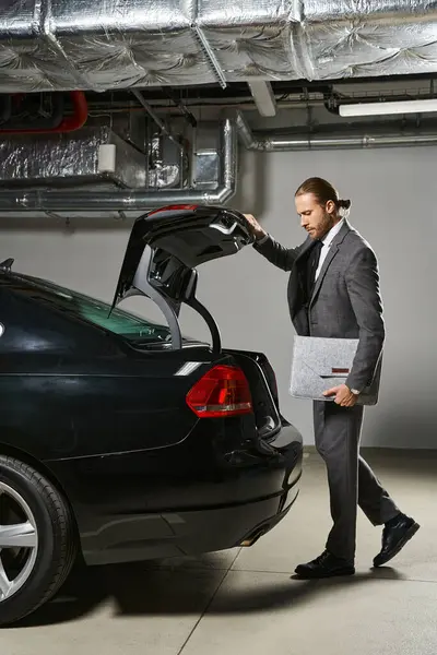 Gut aussehender gepflegter Mann mit roten Haaren im eleganten Anzug, der den Kofferraum seines Autos schließt, Geschäftskonzept — Stockfoto