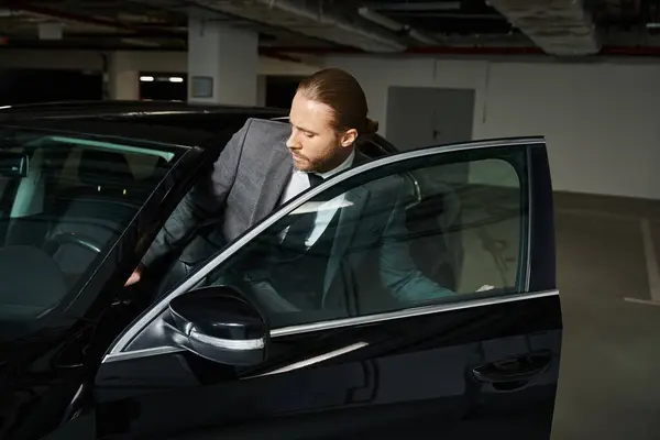 Attractive elegant man in chic smart suit getting into his car on parking lot, business concept — Stock Photo