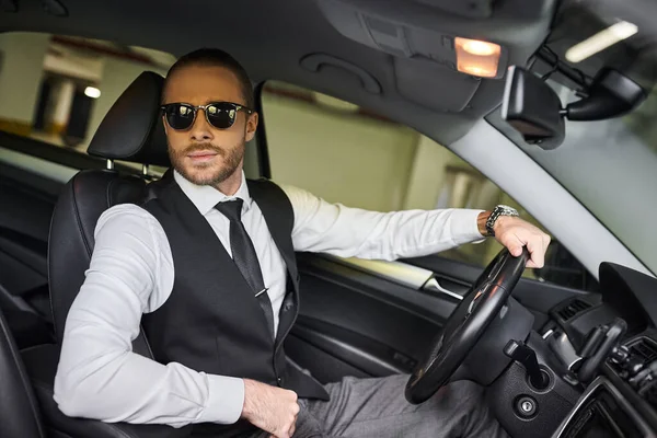 Appealing elegant man in stylish attire with sunglasses behind steering wheel, business concept — Stock Photo