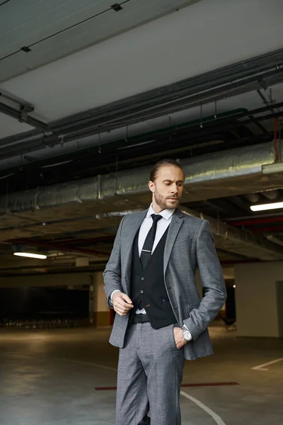 Séduisant homme élégant en costume intelligent gris avec cravate posant avec la main dans la poche, concept d'affaires — Photo de stock