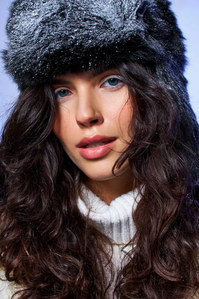 Bella giovane donna in cappello peloso e abbigliamento bianco in posa su sfondo grigio, moda invernale — Foto stock