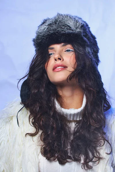 Belleza de invierno, mujer joven con ojos azules posando en traje acogedor blanco sobre fondo gris, aire fresco - foto de stock