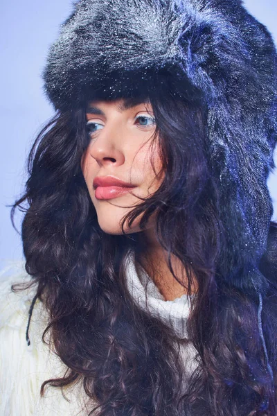 Bellezza invernale, giovane donna in cappello invernale con neve e maglione bianco su sfondo grigio, aria fresca — Foto stock