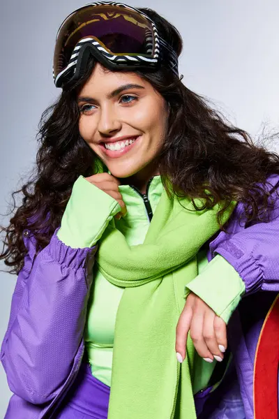 Activité hivernale, portrait d'une femme souriante posant en tenue active avec veste gonflable et skis — Photo de stock