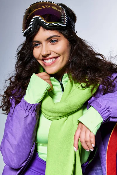 Winter activity, portrait of smiling woman posing in active wear with puffer jacket and skis — Stock Photo
