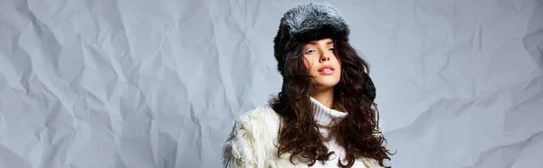 Hermosa mujer en chaqueta de piel sintética blanca, sombrero de invierno y suéter posando sobre fondo gris, pancarta - foto de stock