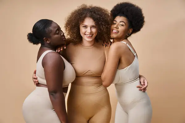 Alegre africana americana mujer sobresaliendo lengua cerca positivo más tamaño novias en beige - foto de stock