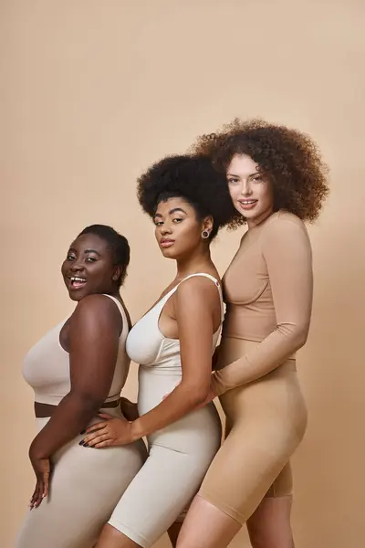 Diverse multietnico plus size donne in biancheria intima sorridente sul beige, il corpo positivo e naturale bellezza — Foto stock