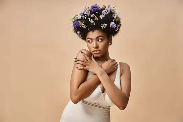 Porträt einer charmanten afrikanisch-amerikanischen Frau mit bunten Blumen im Haar, die auf beige wegschaut — Stockfoto