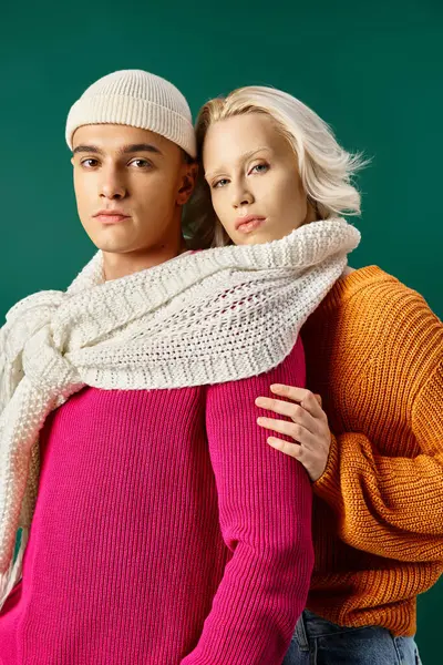 Bella coppia in maglioni condivisione sciarpa bianca e posa insieme su turchese, moda invernale — Foto stock
