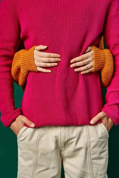 Partial view of woman hugging boyfriend in pink knitted sweater, hands of loving couple — Stock Photo