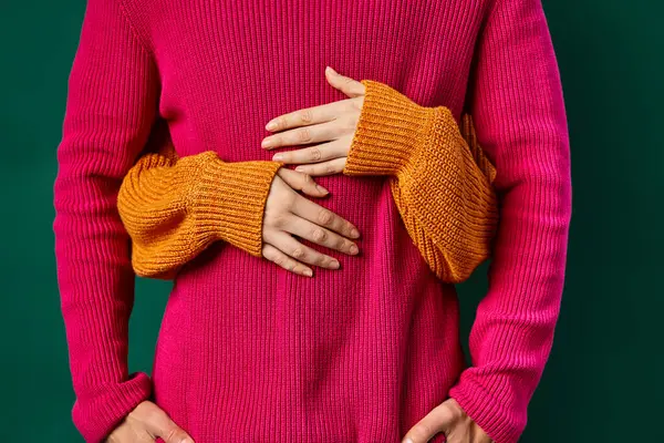 Cropped view of woman hugging boyfriend in pink knitted sweater, hands of loving couple — Stock Photo