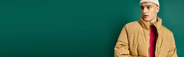 Banner of handsome man in beanie hat and stylish puffer jacket on turquoise background, winter trend — Stock Photo