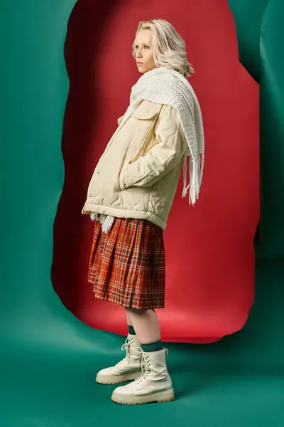 Полная длина блондинка в стильном зимнем наряде позирует на красном с бирюзовым фоном — стоковое фото