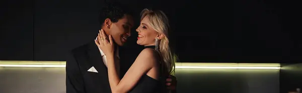 Cheerful multicultural couple in chic attire hugging warmly and smiling at each other, banner — Stock Photo