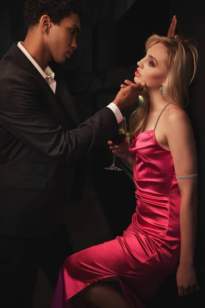 Захоплююча чуттєва різноманітна пара в елегантному вечірньому вбранні позує разом і дивиться один на одного — стокове фото