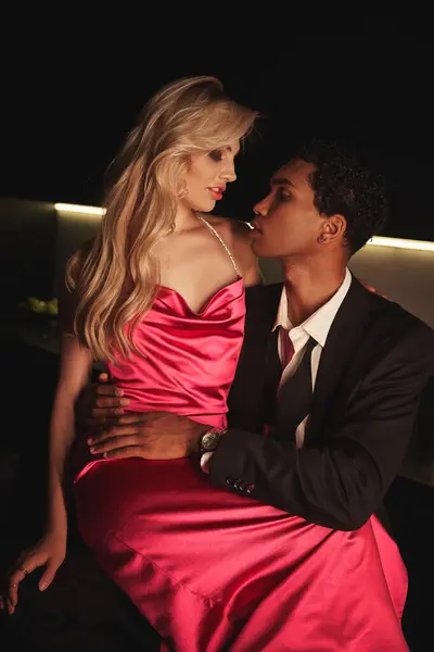 Atraente jovem casal multirracial em trajes elegantes posando juntos e olhando uns para os outros — Fotografia de Stock