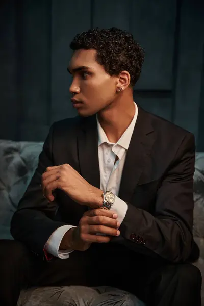 Appealing young african american male model in chic suit with accessories posing and looking away — Stock Photo