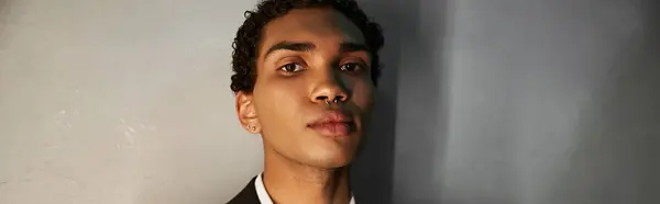 Junger gut aussehender afrikanisch-amerikanischer Mann im eleganten Anzug mit Piercing, der in die Kamera schaut, Banner — Stockfoto