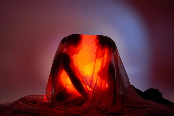 Casal multirracial coberto com lençol cercado por luz sobre fundo cinza, união — Fotografia de Stock