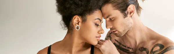 Attrayant couple multiracial en sous-vêtements posant sensuellement et amoureusement dans leur chambre, bannière — Photo de stock