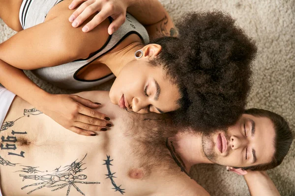 Bastante joven afroamericana mujer acostada en el suelo junto con su novio, sexy pareja - foto de stock